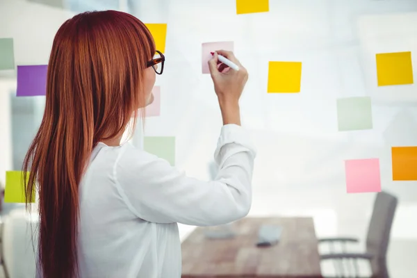Attractive hipster woman writing on sticky notes