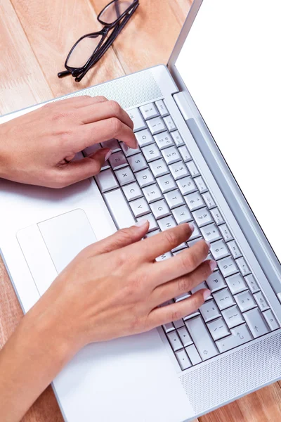 Feminine hands typing on laptop