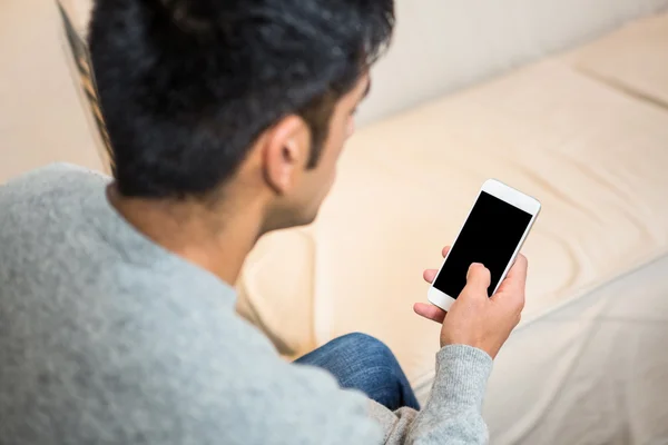 Handsome man using smartphone on the sofa