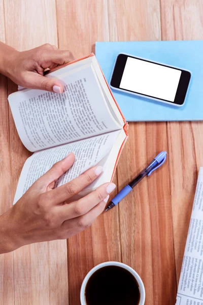 Overhead of feminine hands holding a book