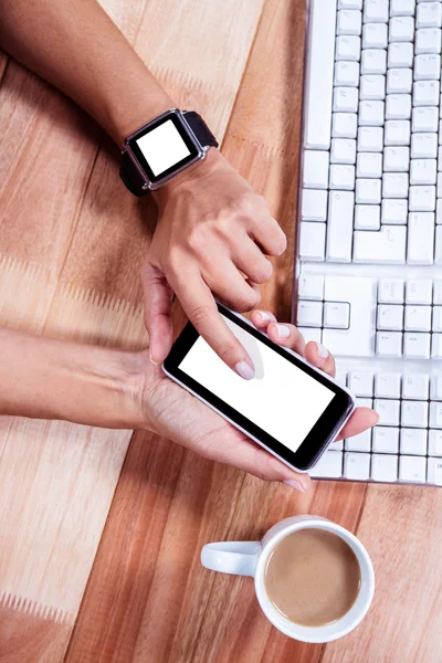 Feminine hands with smartwatch using smartphone