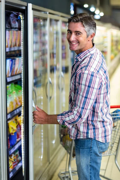 Man opening supermarket fridge