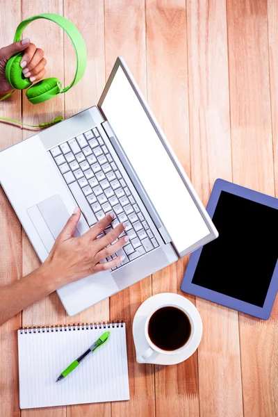 Overhead of feminine hands typing on laptop