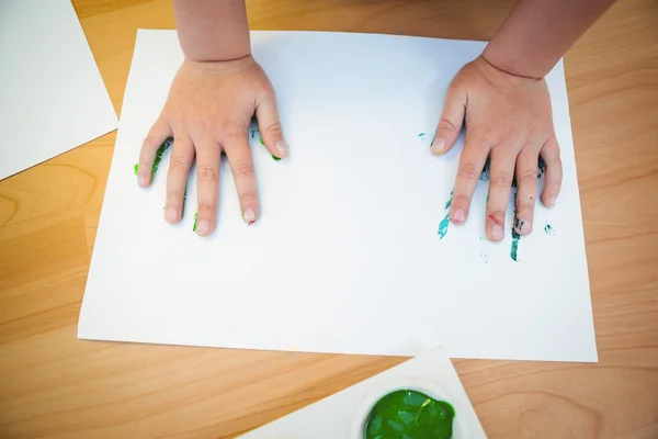 Boy pressing his paint covered hands