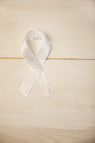 White ribbon on wooden desk