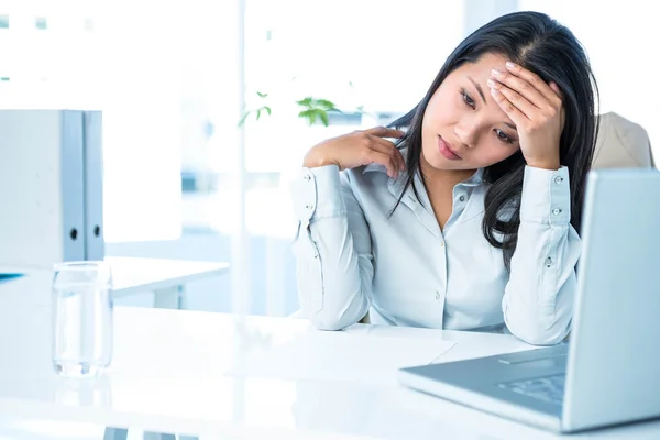 Worried businesswoman holding her head