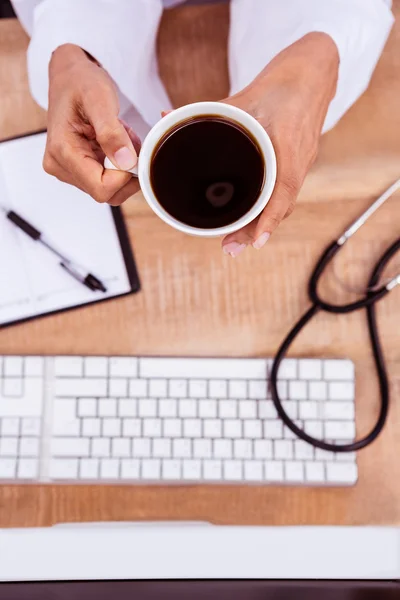 Doctor holding black coffee cup