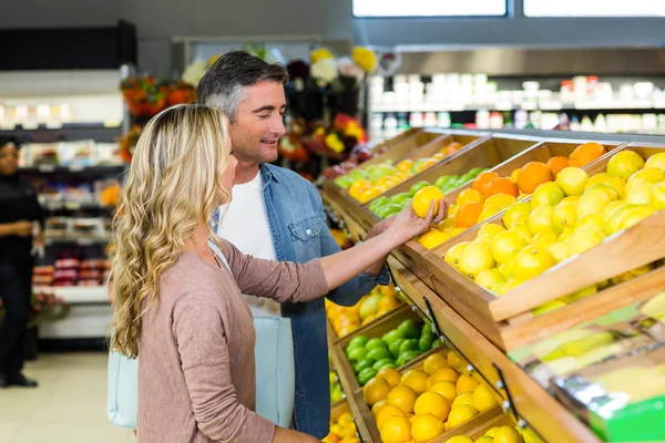 Happy smiling couple picking orange