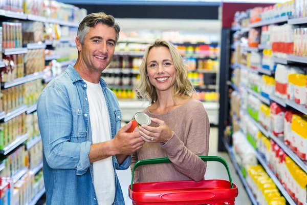 Smiling couple holding canned food