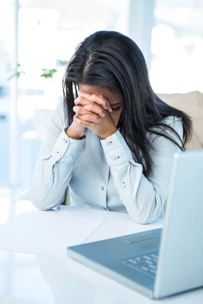 Worried businesswoman covering face