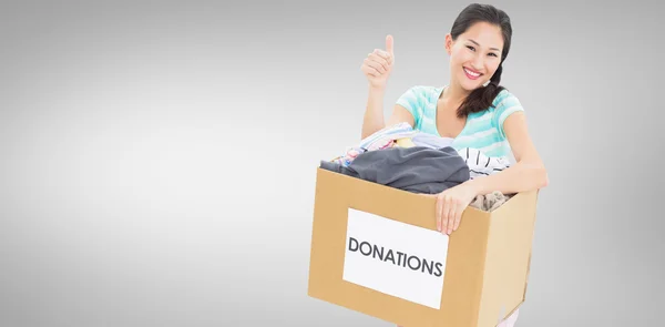 Woman with clothes donation gesturing thumbs