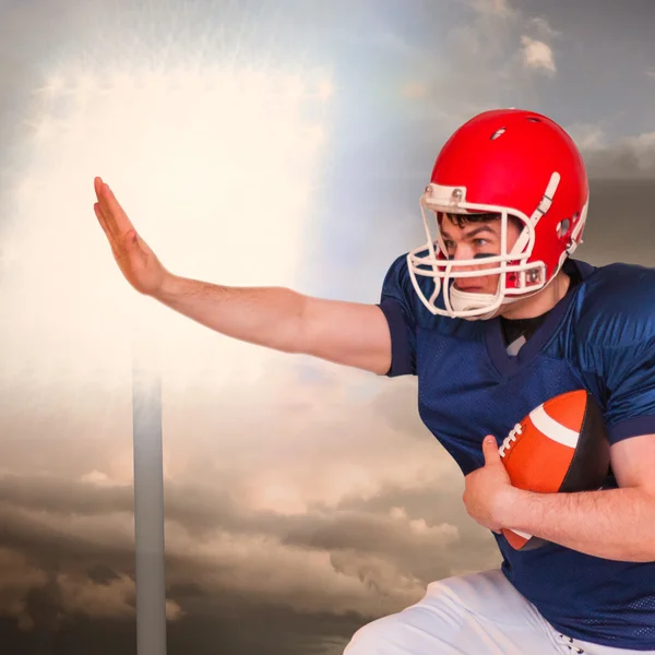 American football player jumping with the ball