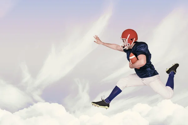 American football player jumping with the ball