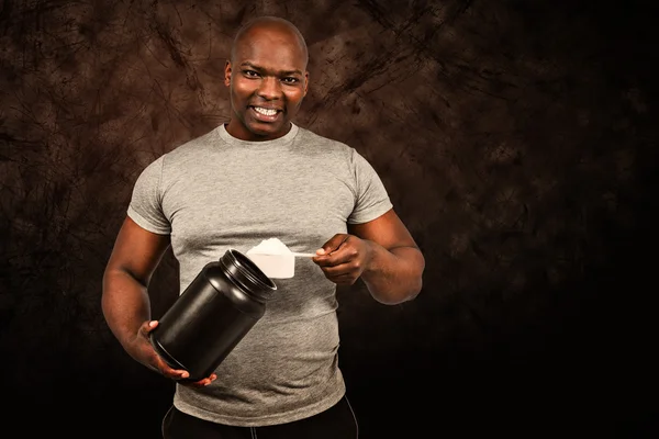 Fit man scooping protein powder