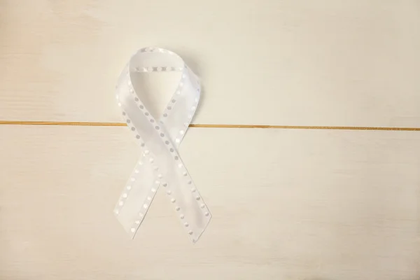 White ribbon on wooden desk