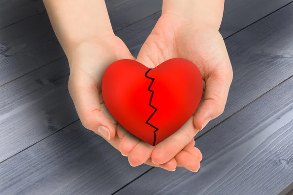 Couple holding broken heart in hand