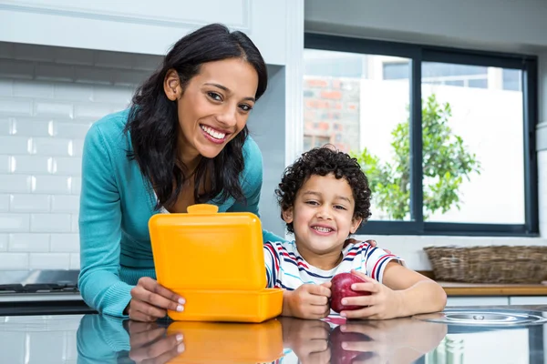 Smiling mother and son going to eat an apple