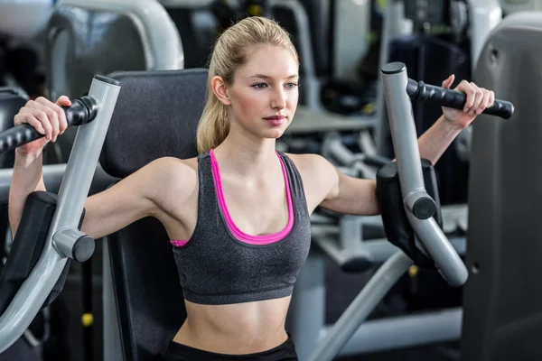 Fit woman using exercise machine