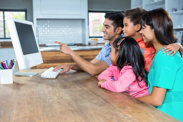 Happy family using computer in the kitchen