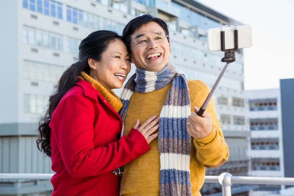 Older asian couple on balcony taking selfie