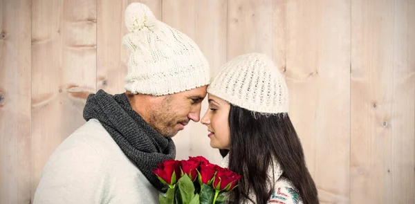 Couple nose-to-nose holding roses bouquet