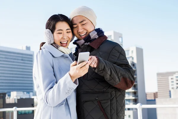 Cheerful couple looking at the smart phone