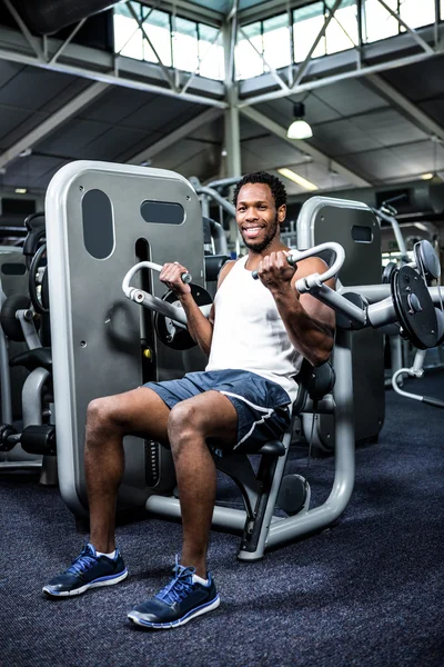 Muscular man using exercise machine