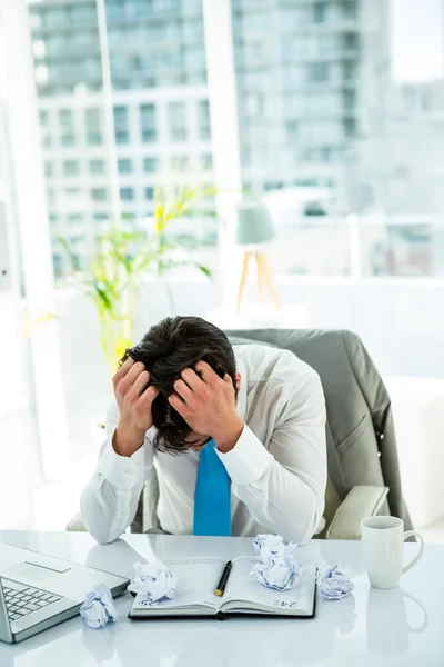 Stressed businessman with head in hands