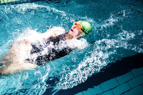 Fit woman swimming with swimming hat