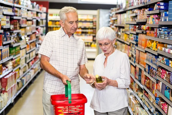 Senior couple holding oil bottle