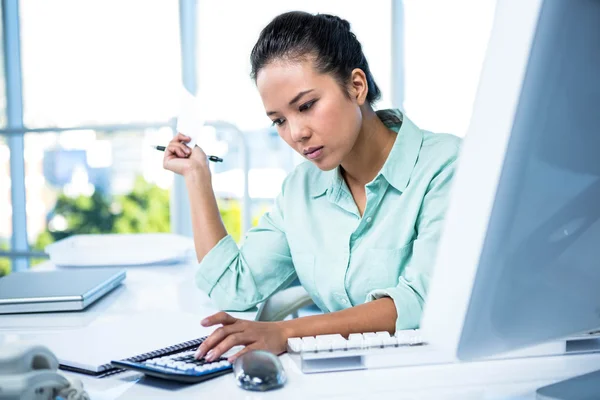 Smiling young businesswoman writing notes