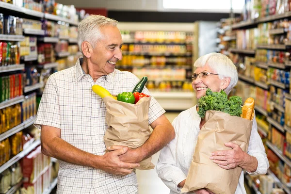 Senior couple holding grocery bags