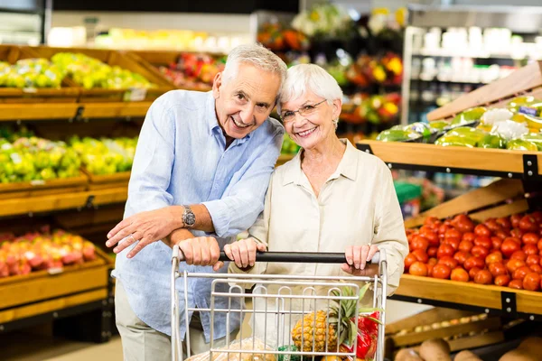 Smiling senior couple at the grocery shop