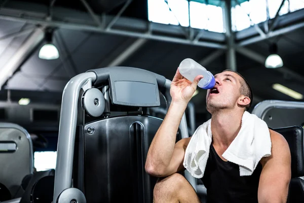 Muscular man drinking water