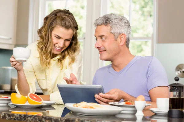 Couple using tablet and having breakfast