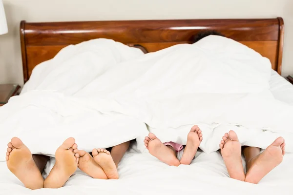 Parents and kids feet at the end of the bed