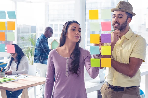 Businesswoman writing on adhesive note