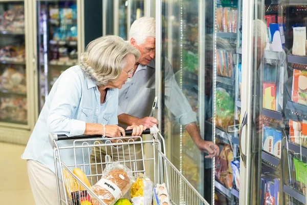 Senior couple with cart buying food