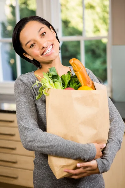 Brunette holding grocery bag