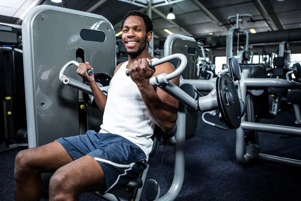Muscular man using exercise machine