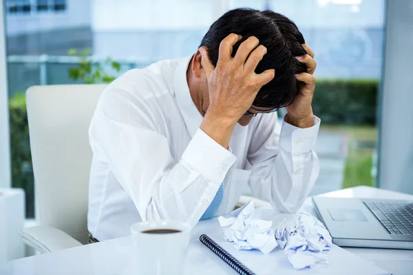 Worried businessman with head in hands