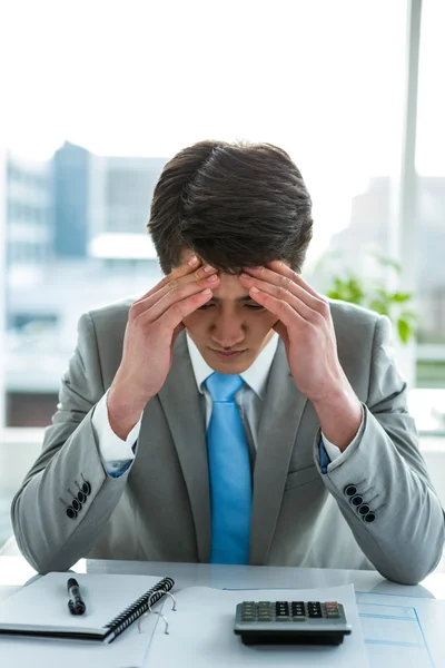 Troubled asian businessman in his desk