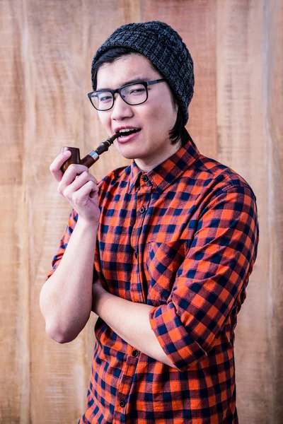 Hipster smoking pipe with crossed arms