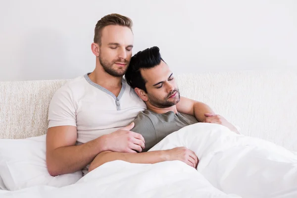 Asleep gay couple lying in bed