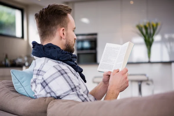 Man reading book on couch