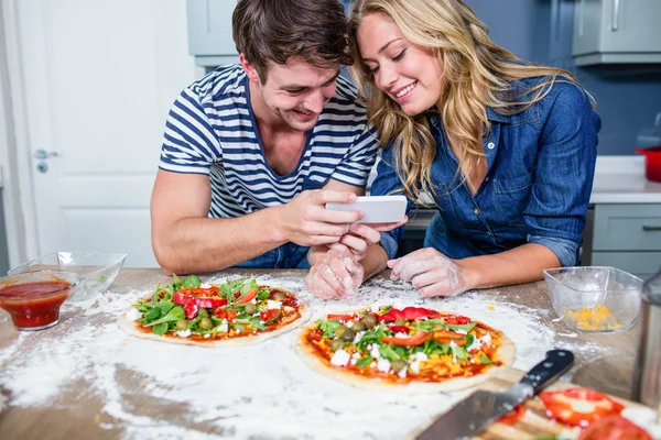 Smiling couple preparing pizza