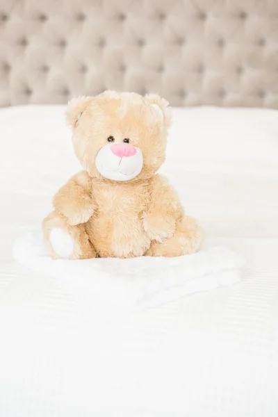 Soft teddy bear on bed