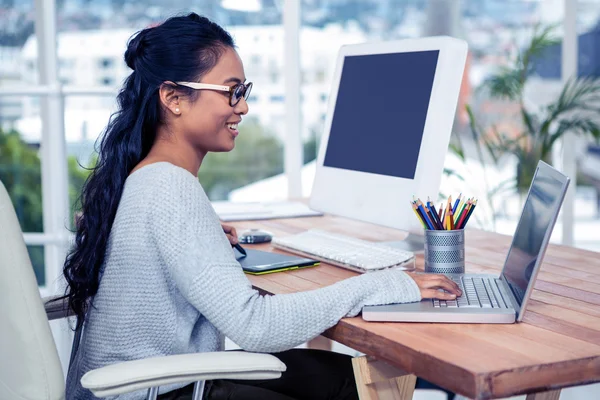 Woman using laptop and digital board