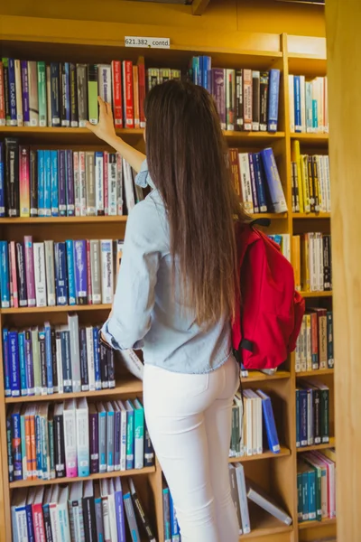 Brunette student picking out book