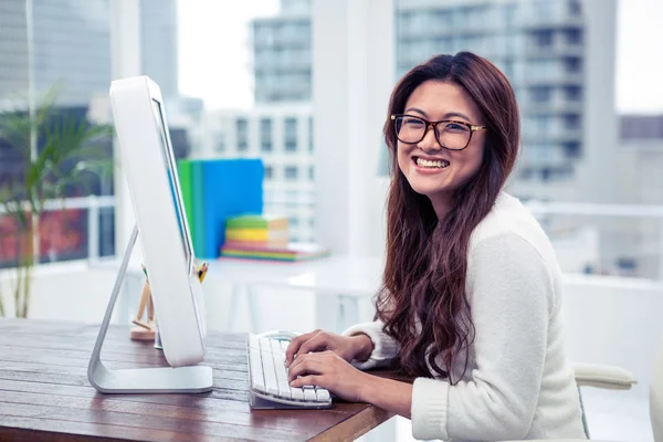 Smiling Asian woman on computer